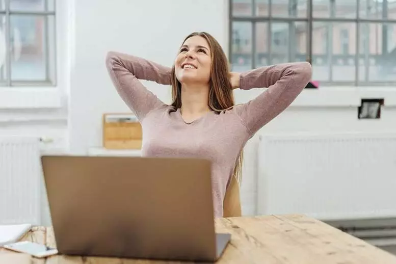 Fröhliche Frau vor einem Laptop