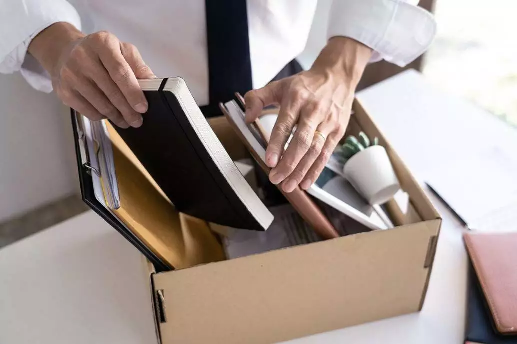Mann packt Dinge in einen Karton